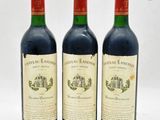 trois bouteilles de vin rouge posées l'une à côté de l'autre sur une surface blanche