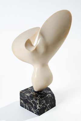 sculpture en marbre de forme abstraite posée sur un socle en marbre noir