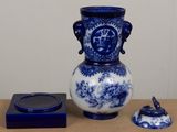 a blue and white vase sitting on a table next to a candle holder