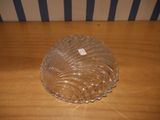 a glass bowl sitting on a wooden table with a striped wall behind it