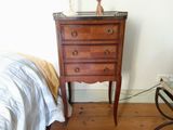 une petite commode dans un coin d'une chambre