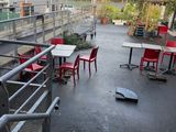 tables and chairs on the ground outside of a building