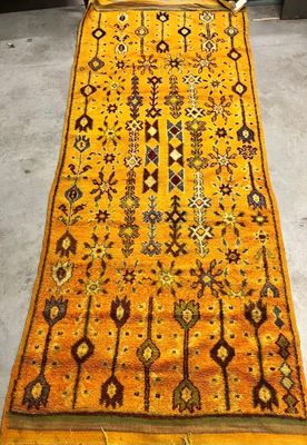 an orange and brown rug on a grey floor in a room