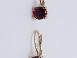 a pair of earrings with garnets on a white background