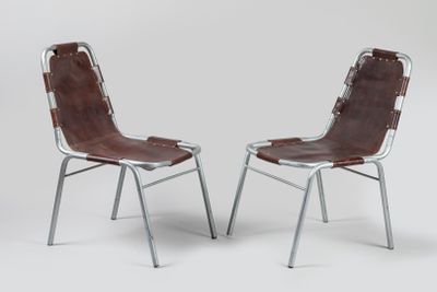 deux fauteuils en cuir marron avec des pieds en métal, sur fond blanc