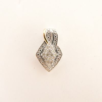 gros plan d'un pendentif en diamant sur une surface blanche