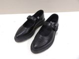 pair of black leather shoes with buckles on a white surface
