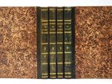 trois livres sont alignés les uns sur les autres sur une surface blanche