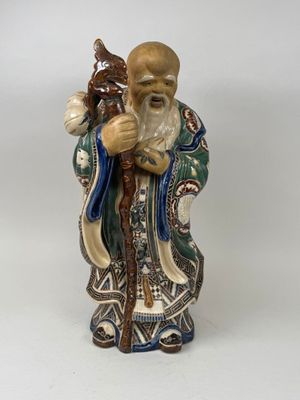 une image représentant une figurine d'un homme tenant un bâton