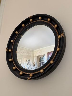 a round mirror hanging on the wall in a room