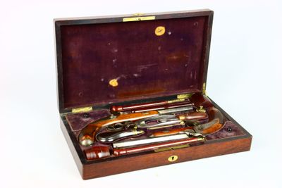 une mallette en bois contenant quatre types d'armes à feu différents