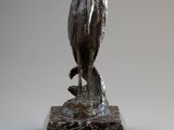 statue of a bird on a rock on a white background