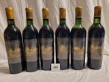 six bottles of wine are lined up on a table