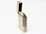 un briquet argenté posé sur une surface blanche