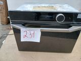 un four noir posé sur une boîte en carton sur laquelle est collée une étiquette de prix
