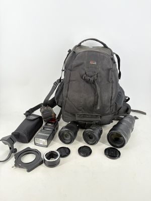 un sac à dos contenant un appareil photo, un objectif et d'autres objets