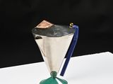a silver cup with a blue handle on a white table