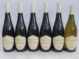 six bottles of wine are lined up in a row on a table