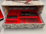 de nombreuses fourchettes et cuillères dans une boîte posée sur une table