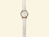 the watch is white with a silver face and a leather strap