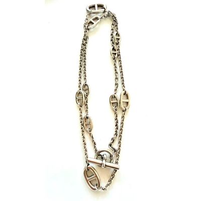 gros plan d'un collier sur une surface blanche avec une chaîne
