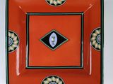 une assiette orange ornée d'un motif en noir et blanc