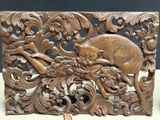 a wooden carving of a cat on a tree branch