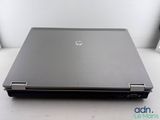 the back of a laptop computer sitting on top of a white table