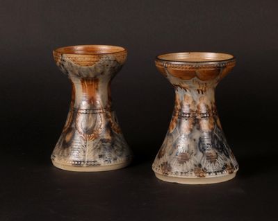two vases sitting side by side on a black surface