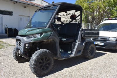 un véhicule utilitaire vert garé devant un camion blanc