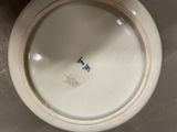 a white bowl with blue writing on it on a table