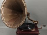 un vieux phonographe avec un socle et un boîtier en bois