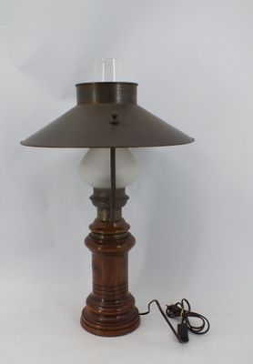 une lampe à l'ancienne avec un pied en bois et un abat-jour en verre