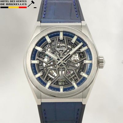 une image représentant une montre avec un bracelet bleu sur fond blanc