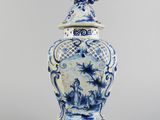 an image of a blue and white vase with a bird on top of it