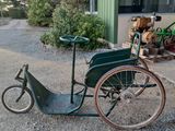 a small green bike parked in front of a building