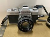 a silver camera and a black camera on a table