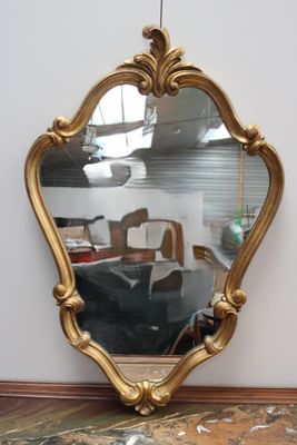 un miroir posé sur le sol à côté d'une chaise