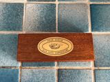 a wooden plaque on a tile floor with a fish on it