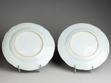 pair of blue and white plates with gold rims on stands