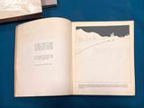 an open book on a table with a blue table cloth
