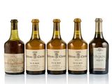 six bottles of wine are lined up on a white surface