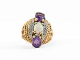un gros plan d'une bague en or sertie d'une pierre violette et blanche