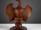 une photo d'une sculpture en bois représentant un oiseau sur un socle