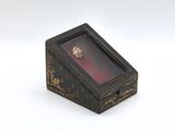 a small wooden box that has a ring in it