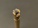 a close up of a small metal object on a gray surface