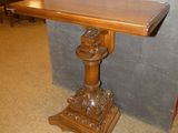 a wooden table with a wooden top on a carpeted floor