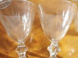 several empty wine glasses sitting on a wooden table with a knife
