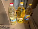 plusieurs bouteilles d'huile posées sur une pile de cartons