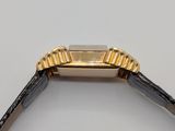 a close up of a watch on a white surface with a black strap